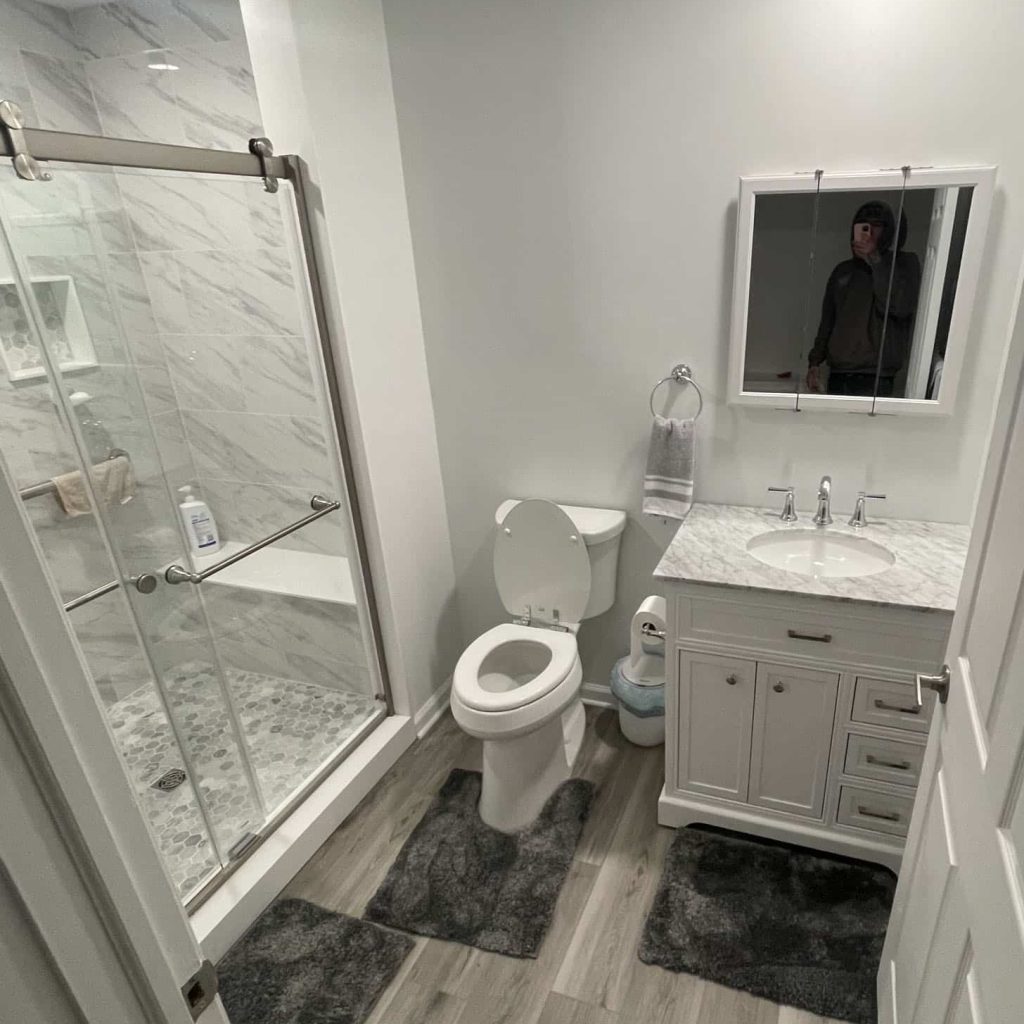 Elegant marble-finished bathroom remodel in Levittown by J. Tretter and Sons with polished countertops and walls.